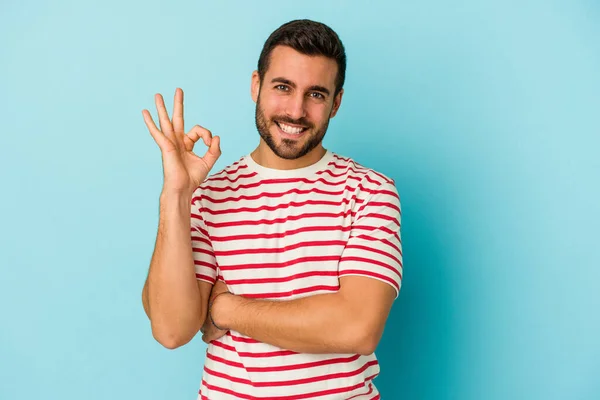 Young Caucasian Man Isolated Blue Background Winks Eye Holds Okay — Stock Photo, Image