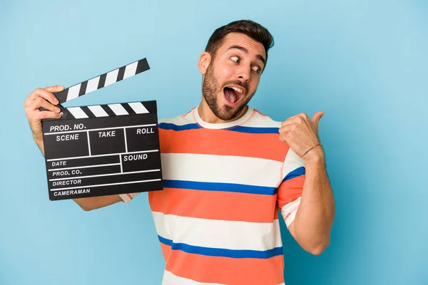 Young Caucasian Man Holding Clapperboard Isolated Blue Background Points Thumb — Stock Photo, Image