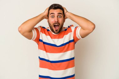 Beyaz arka planda izole olmuş genç beyaz bir adam çığlık atıyor, çok heyecanlı, tutkulu, bir şeyden memnun..