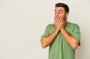 Beyaz arka planda izole edilmiş beyaz tenli genç adam ağzını eliyle kapatan bir fotokopi odasına bakıyor..