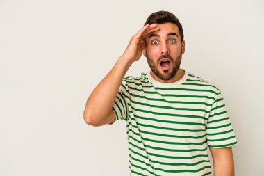 Beyaz arka planda izole genç beyaz adam yüksek sesle bağırıyor, gözleri açık ve elleri gergin tutuyor..