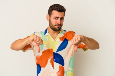 Beyaz arka planda izole edilmiş genç beyaz adam baş parmağını aşağı gösteriyor, hayal kırıklığı konsepti..