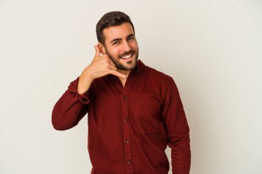 Beyaz arka planda izole edilmiş genç beyaz bir adam parmakları olan bir cep telefonu hareketi gösteriyor..