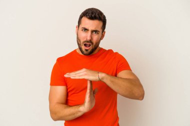 Beyaz arka planda izole edilmiş genç beyaz bir adam bir mola hareketi gösteriyor..