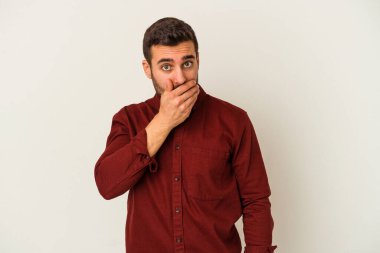 Beyaz arka planda izole edilmiş genç beyaz bir adam ağzı kapalı ve elleri endişeli görünüyor..