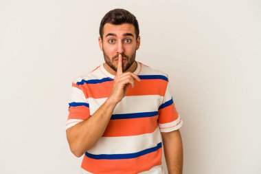 Beyaz arka planda izole edilmiş genç beyaz bir adam ya sır saklıyor ya da sessizlik istiyor..