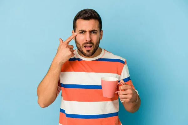 Joven Hombre Caucásico Sosteniendo Una Taza Aislada Sobre Fondo Azul —  Fotos de Stock