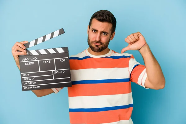 Young Caucasian Man Holding Clapperboard Isolated Blue Background Feels Proud — Stock Photo, Image