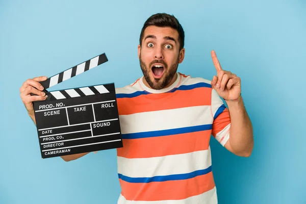 Young Caucasian Man Holding Clapperboard Isolated Blue Background Having Idea — Stock Photo, Image