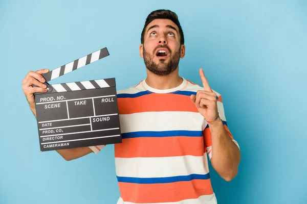 Young Caucasian Man Holding Clapperboard Isolated Blue Background Pointing Upside — Stock Photo, Image