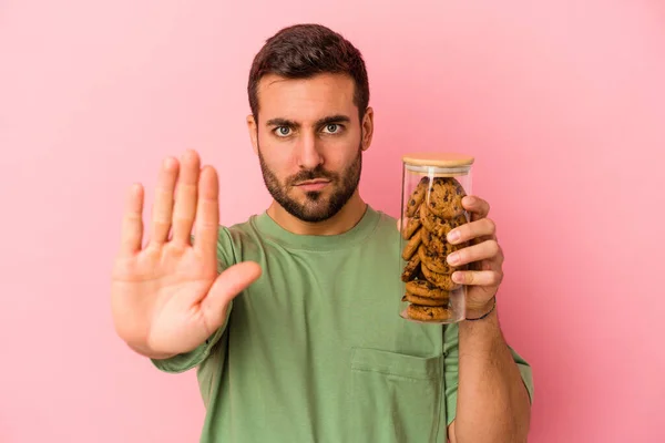 Junger Kaukasischer Mann Mit Plätzchenglas Isoliert Auf Rosa Hintergrund Stehend — Stockfoto