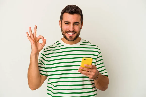 Młody Biały Mężczyzna Trzyma Telefon Komórkowy Odizolowany Biały Tło Wesoły — Zdjęcie stockowe