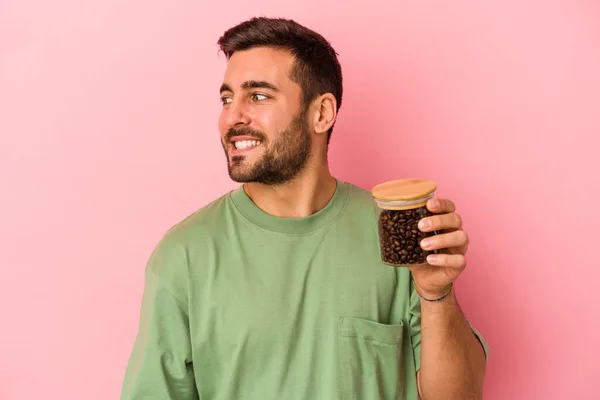 Młody Biały Mężczyzna Trzymając Butelkę Kawy Odizolowany Różowym Tle Patrzy — Zdjęcie stockowe