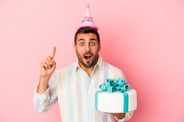 Genç beyaz adam doğum gününü pembe arka planda yalnız kutluyor. Bir fikri var, ilham verici bir kavram..