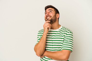 Beyaz arka planda izole edilmiş genç beyaz bir adam rahatlamış bir şeyin fotokopi odasına baktığını düşünüyor..