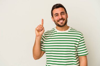 Beyaz arka planda izole edilmiş beyaz tenli genç bir adam bir numarayı parmağıyla gösteriyor..
