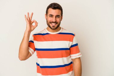 Beyaz arka planda izole edilmiş genç beyaz bir adam neşeli ve kendinden emin..