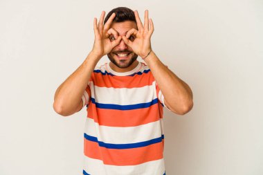 Beyaz arka planda izole edilmiş genç beyaz bir adam gözlerinde sorun olmadığını gösteriyor.