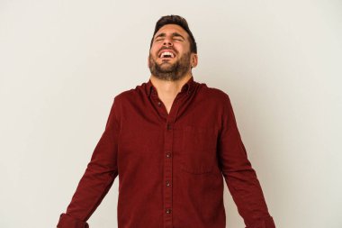 Beyaz arka planda izole edilmiş genç beyaz adam gevşemiş ve mutlu bir şekilde gülüyor, boynunda dişlerini gösteriyor..