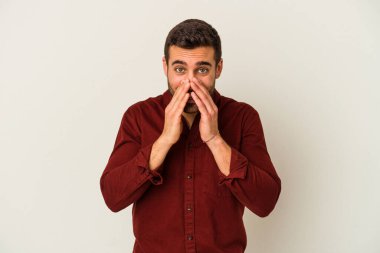 Beyaz arka planda izole edilmiş genç beyaz bir adam bir dedikodu söylüyor, bir haber sunuyor..