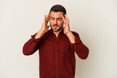 Beyaz arka planda izole edilmiş genç beyaz bir adam tapınaklara dokunuyor ve başı ağrıyor..