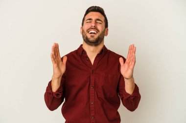 Beyaz arka planda izole genç beyaz adam yüksek sesle gülüyor elini göğsüne koyuyor..