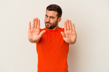 Beyaz arka planda izole edilmiş genç beyaz bir adam elini uzatmış, dur işareti göstererek seni engelliyor..