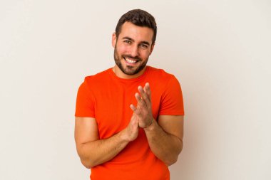 Beyaz arka planda izole olmuş genç beyaz bir adam enerjik ve rahat hissediyor, ellerini ovuşturuyor..