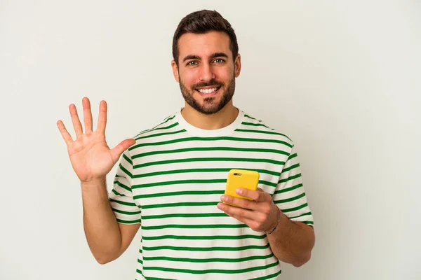 Young Caucasian Man Holding Mobile Phone Isolated White Background Smiling — Stock Photo, Image