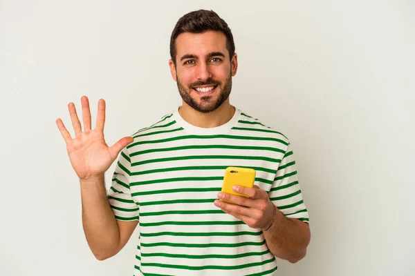 Joven Hombre Caucásico Sosteniendo Teléfono Móvil Aislado Sobre Fondo Blanco — Foto de Stock