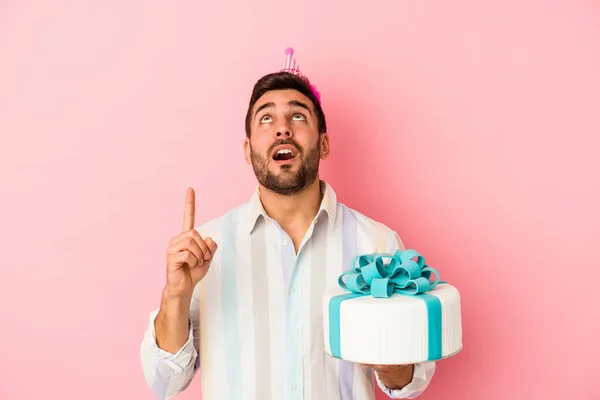 若いですCaucasian男祝います彼の誕生日孤立した上にピンクの背景ポインティングアップサイドでオープン口 — ストック写真