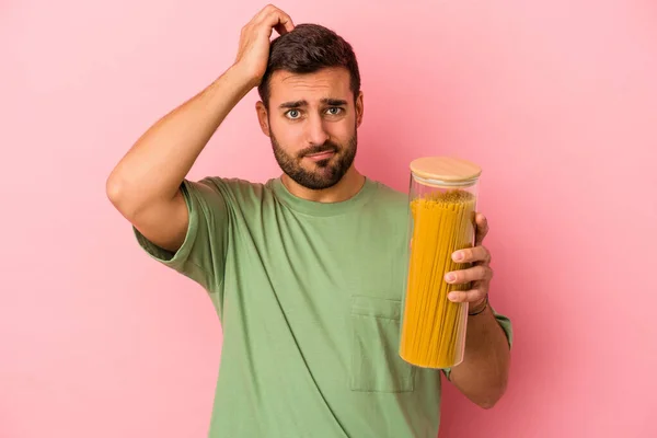 Joven Hombre Caucásico Sosteniendo Tarro Pasta Aislado Sobre Fondo Rosa — Foto de Stock