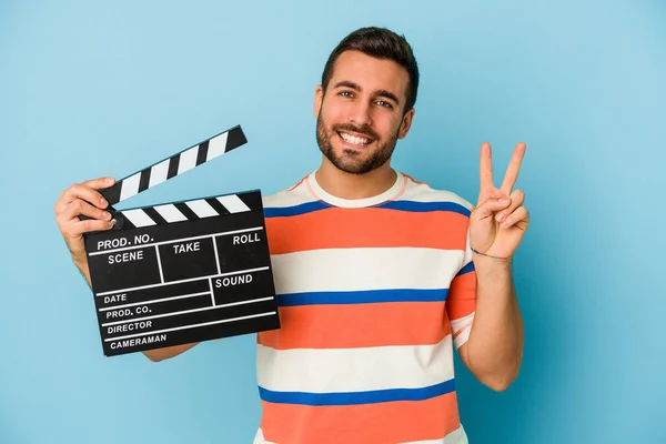 Ung Kaukasier Man Som Håller Clapperboard Isolerad Blå Bakgrund Visar — Stockfoto