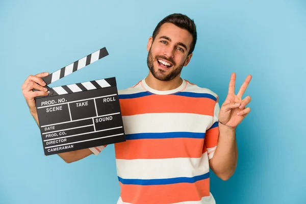 Young Caucasian Man Holding Clapperboard Isolated Blue Background Joyful Carefree — Stock Photo, Image