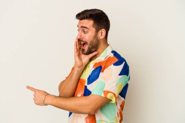 Beyaz arka planda izole edilmiş genç beyaz bir adam bir dedikodu söylüyor, bir haber sunuyor..