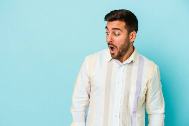 Kafkasyalı genç adam mavi arka planda izole edilmişti. Gördüğü bir şey yüzünden şok olmuştu..