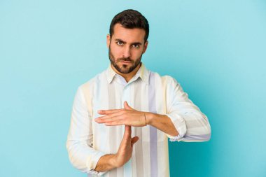 Mavi arka planda izole edilmiş genç beyaz bir adam bir mola hareketi gösteriyor..