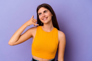 Mor arka planda izole edilmiş genç beyaz kadın parmakları olan bir cep telefonu hareketi gösteriyor..