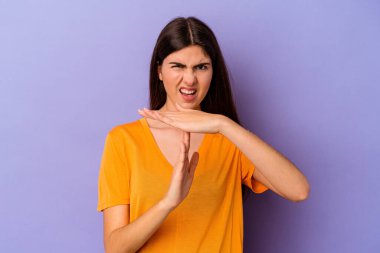 Mor arka planda izole edilmiş genç beyaz kadın bir mola hareketi gösteriyor..