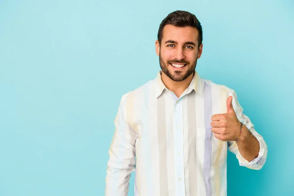 Junger Kaukasischer Mann Auf Blauem Hintergrund Isoliert Lächelt Und Hebt — Stockfoto