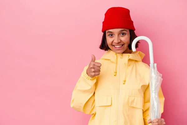 Pembe Arka Planda Şemsiye Tutan Genç Melez Kadın Gülümsüyor Başparmağını — Stok fotoğraf