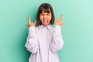 Genç melez kadın mavi üzerine izole edilmiş boynuzlarını bir devrim konsepti olarak gösteriyor..