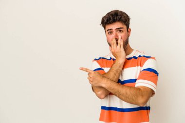 Beyaz arka planda izole edilmiş genç beyaz adam yan tarafı işaret ediyor