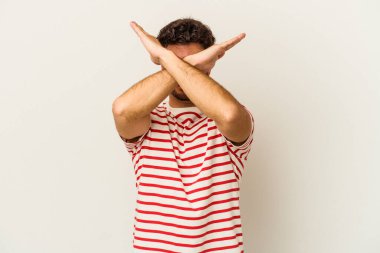 Beyaz arka planda izole genç beyaz adam iki kolu çapraz tutuyor, inkar kavramı.