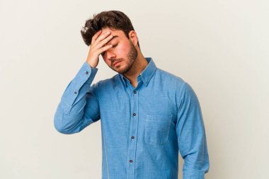 Beyaz arka planda izole edilmiş genç beyaz bir adam tapınaklara dokunuyor ve başı ağrıyor..