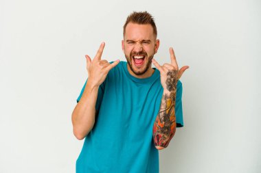 Genç dövmeli, beyaz arka planda izole edilmiş beyaz bir adam boynuzlarını devrim konsepti olarak gösteriyor..