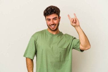 Beyaz arka planda izole edilmiş genç beyaz bir adam boynuzlarını devrim konsepti olarak gösteriyor..