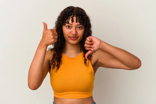 親指と親指を下に示す白い背景に隔離された若い混合人種の女性 難しい選択の概念 — ストック写真