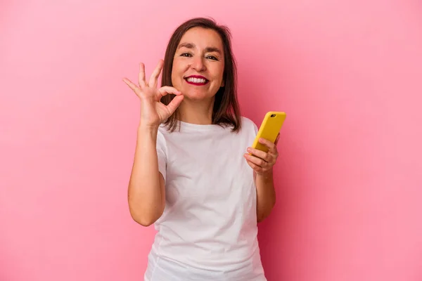 Medelålders Kaukasiska Kvinna Som Håller Mobiltelefon Isolerad Rosa Bakgrund Glad — Stockfoto