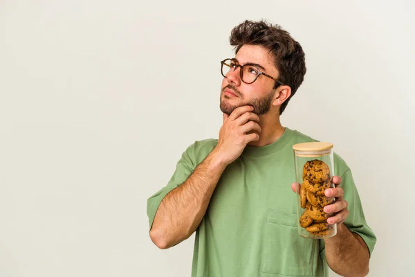 Ung Kaukasier Man Håller Kakor Burk Isolerad Vit Bakgrund Tittar — Stockfoto